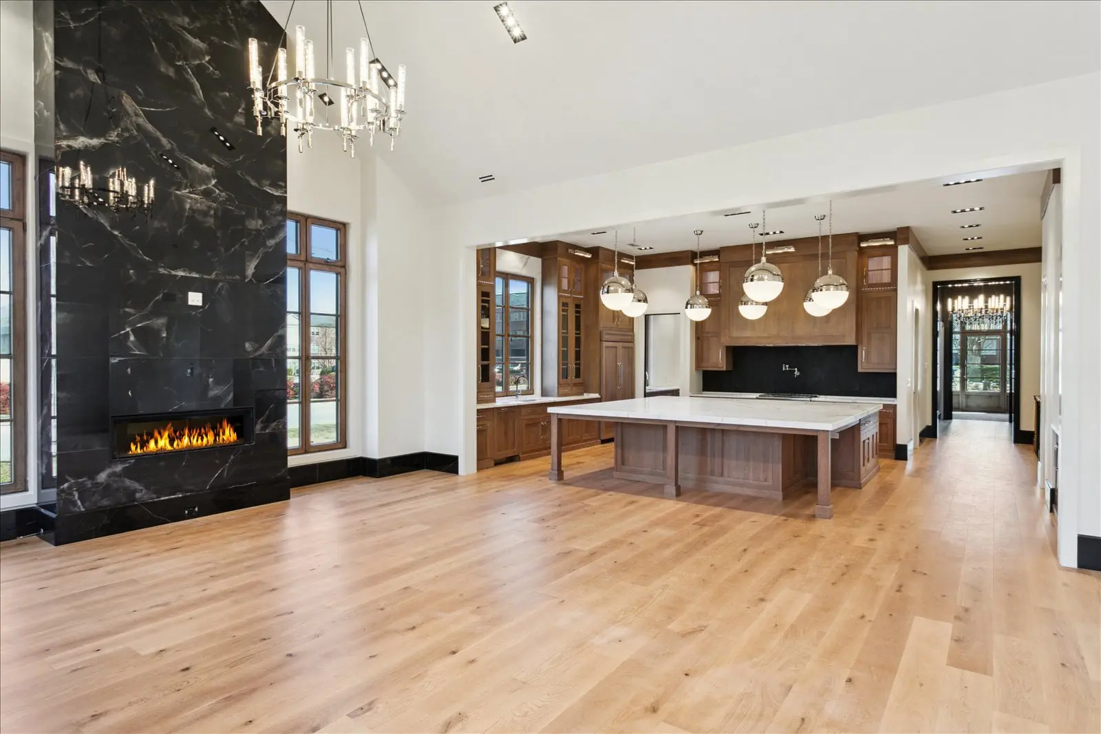 BAC kitchen and living area with island, cabinetry, pendant lights, and fireplace